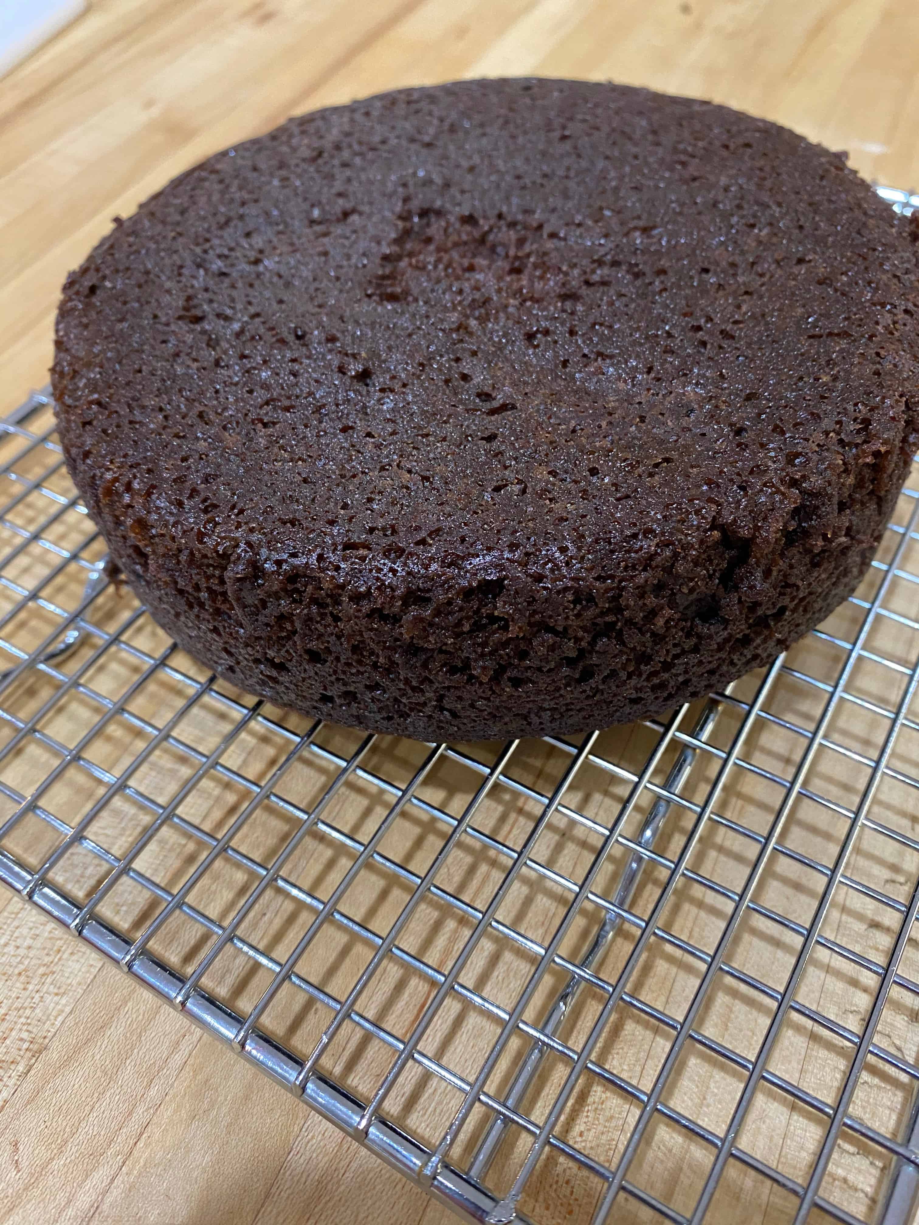 Chocolate cake cooling on rack.