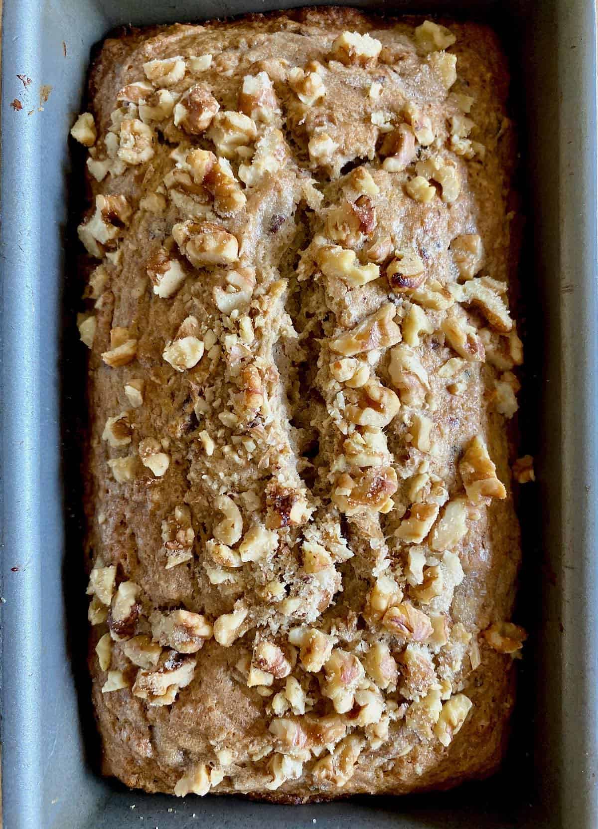 Loaf of banana bread topped with nuts.