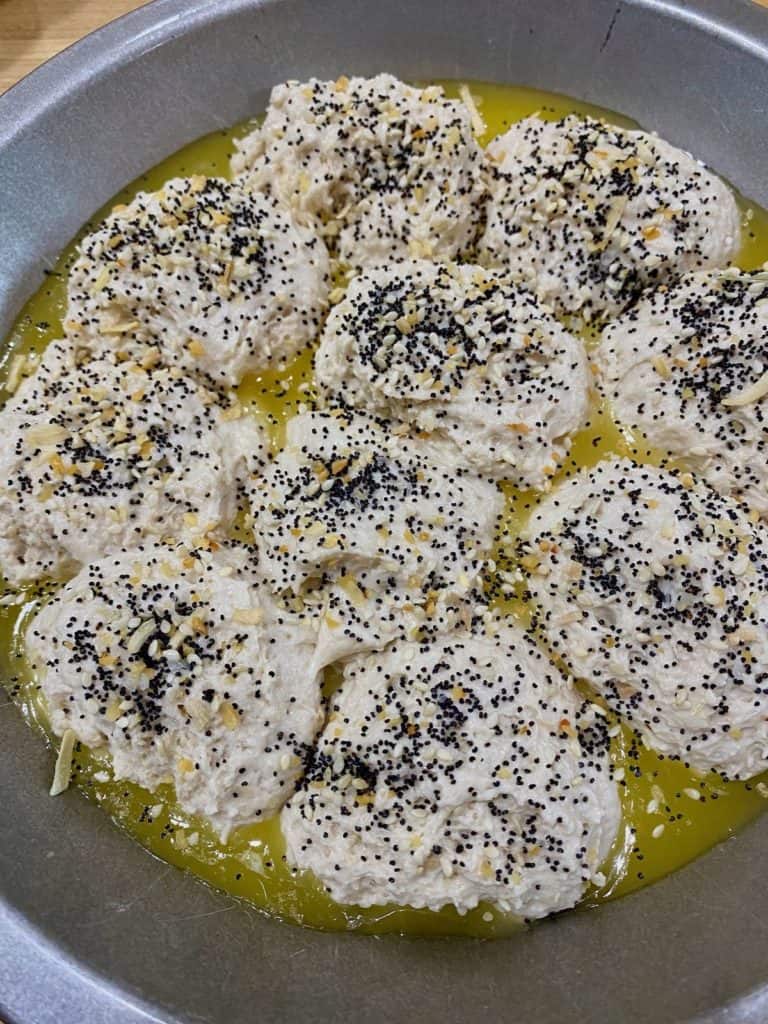 unbaked biscuits in pan with butter and everything bagel topping