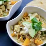 Bowl of Thai chicken chili topped with avocado and tortillas.