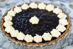 wild berry pie topped with meringue stars sitting on counter