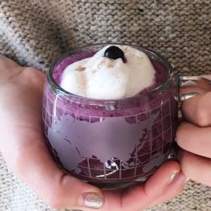 hands holding blueberry latte