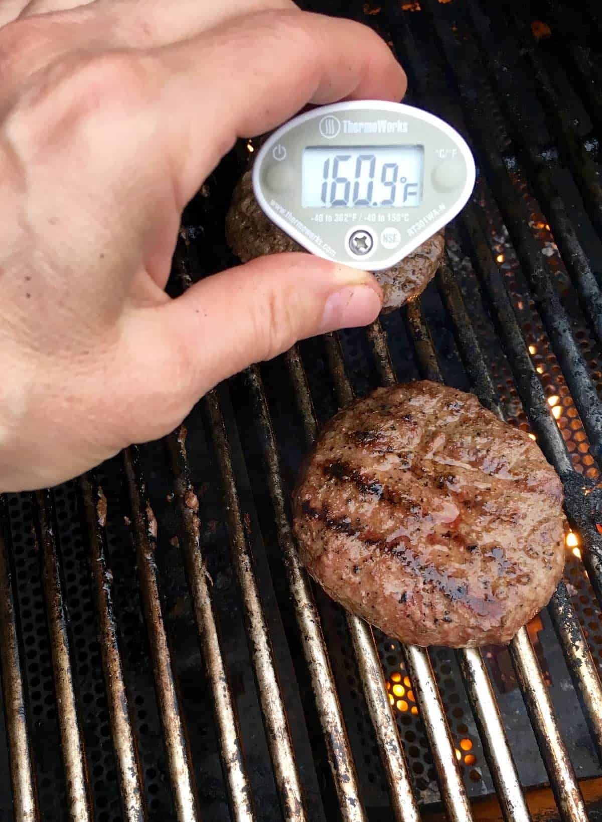 Grilled burgers with instant read thermometer 160.9F.
