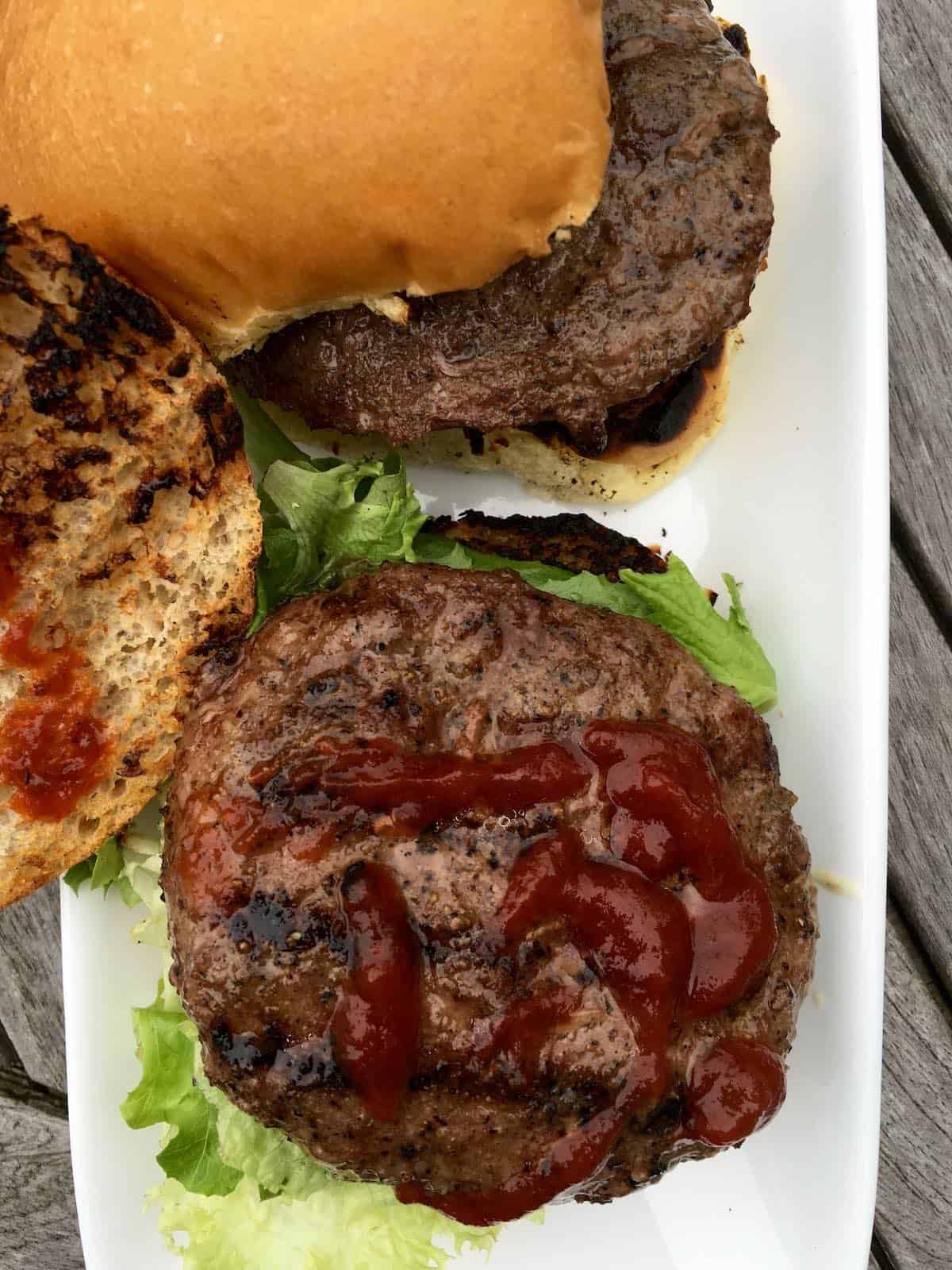 Grilled burgers with ketchup and lettuce