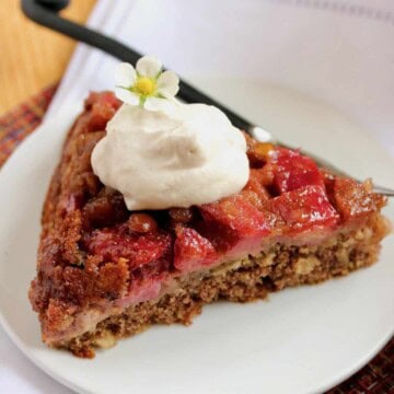 Slice of strawberry rhubarb skillet cake with whipped cream.