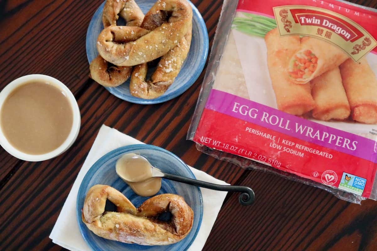 Product wrapper with egg roll pretzels twisted into traditional pretzel shape on blue plates with caramel dip.