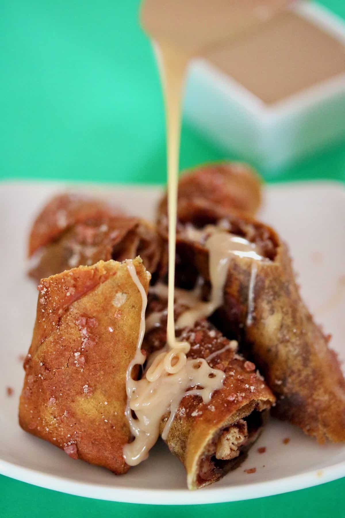 Sliced egg roll pretzels drizzled with caramel.