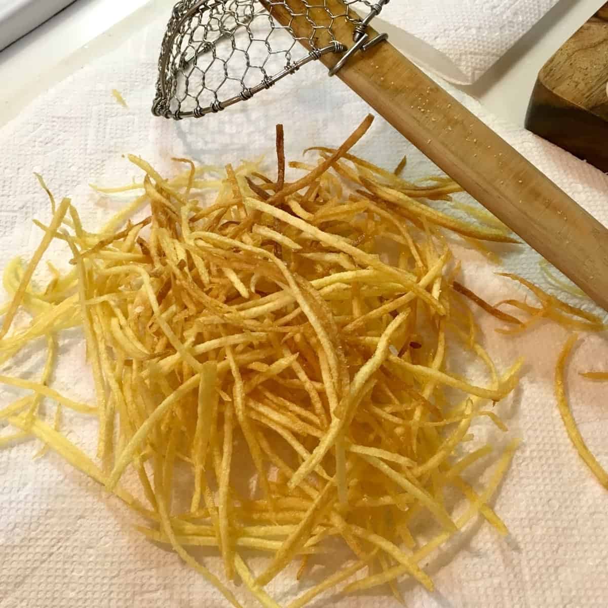 use a russet potato and pat dry with paper towels for extra crispy potato strings