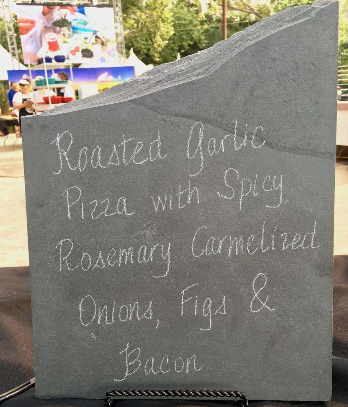 a day in the life of a cook-off contestant shows a sign of her recipe roasted garlic pizza with spicy rosemary carmelized onions, figs and bacon