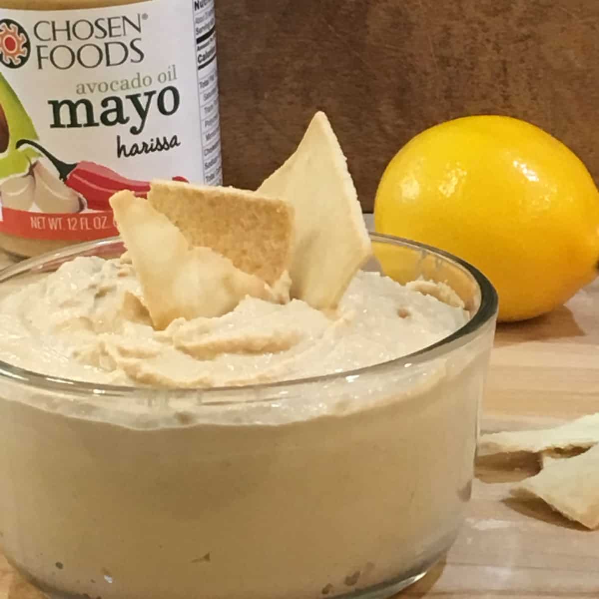 Hummus with lemon and chips with product jar.