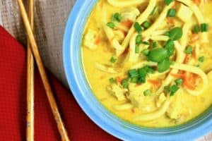 bowl of mulligatawny noodle soup with chop sticks