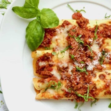 Plated manicotti with basil.