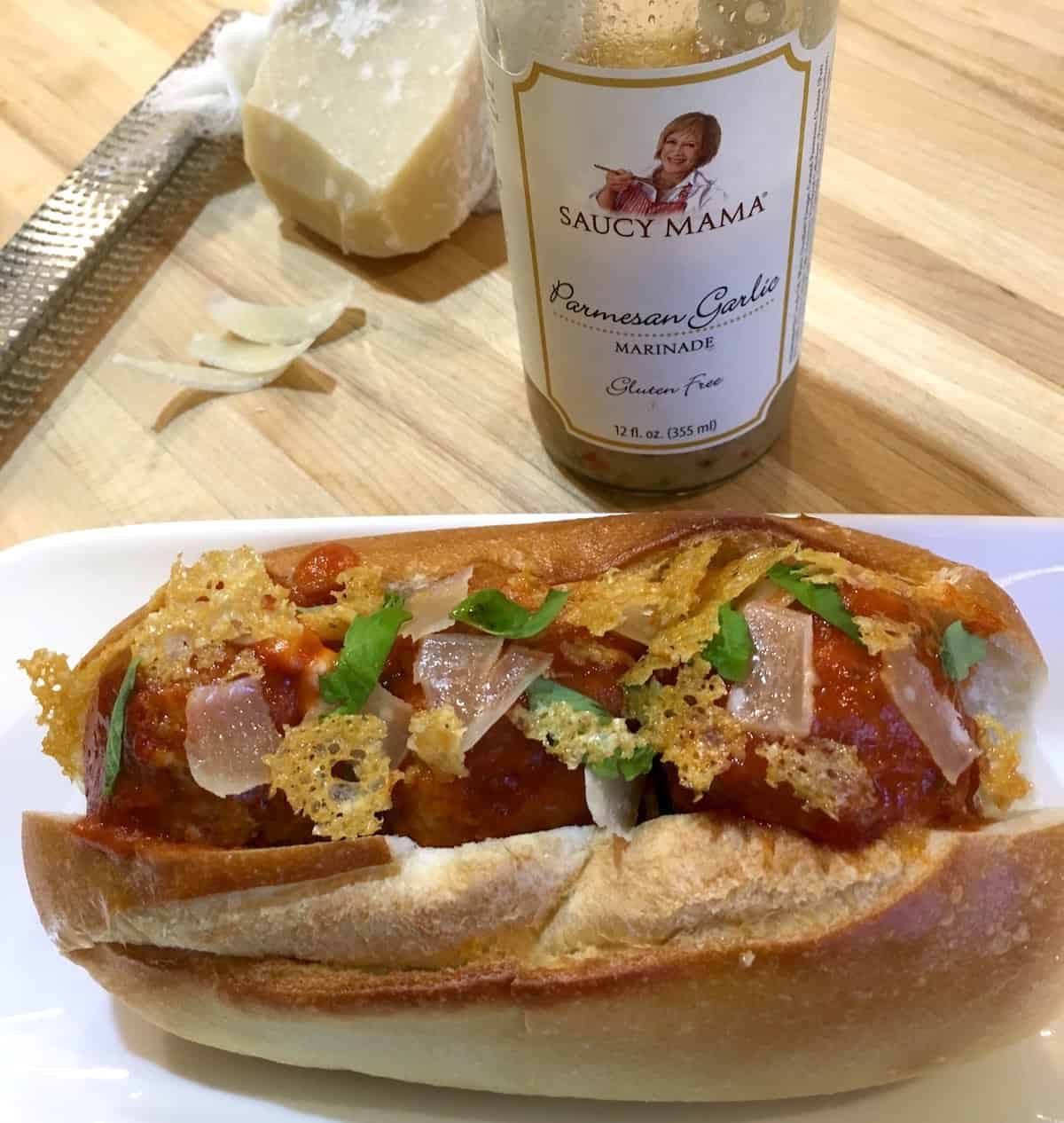 Saucy Mama meatball sub with product bottle
