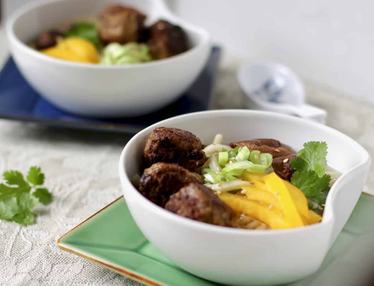 two bowls of mushroom meatball noodle soup