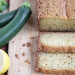 sliced zucchini bread with fresh cut lemon and zucchini on cutting board