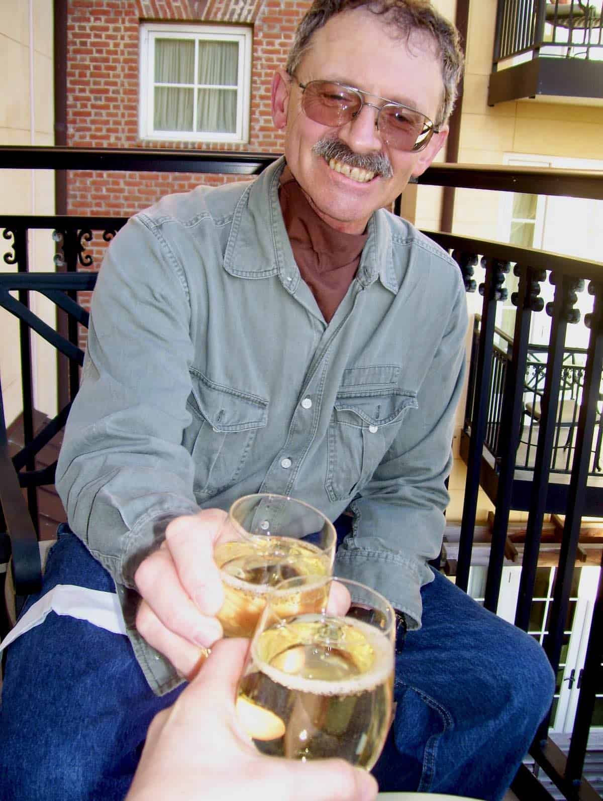 My husband making a toast with wine glass.