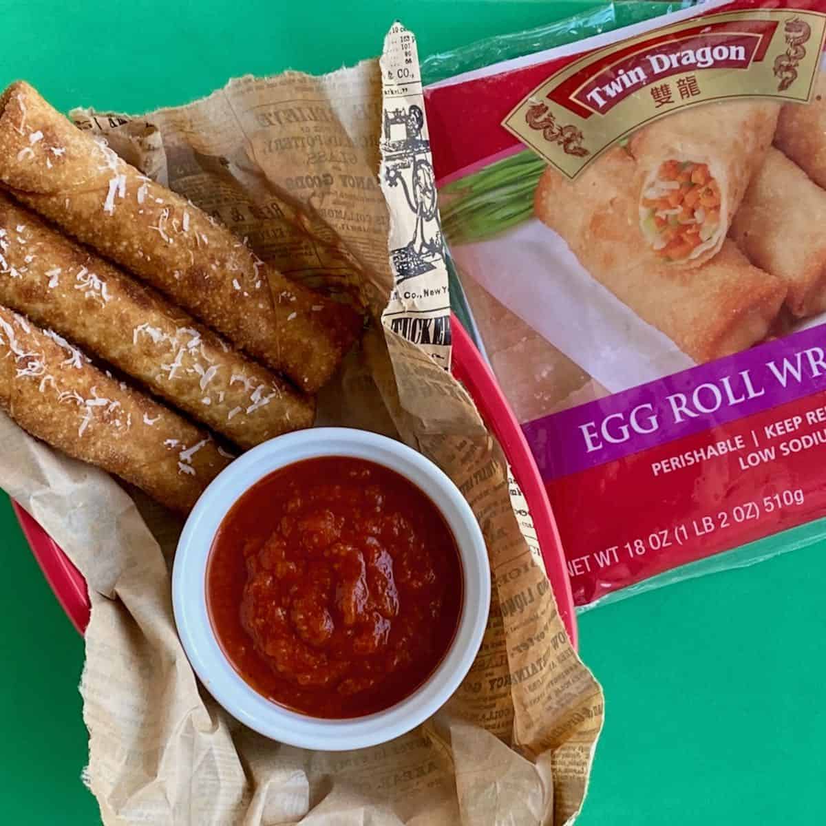 Over head view of egg rolls in a paper lined basket with product package.