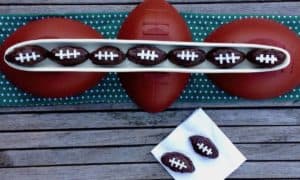 Chocolate covered salted caramel PB pretzel balls decorated to look like footballs.