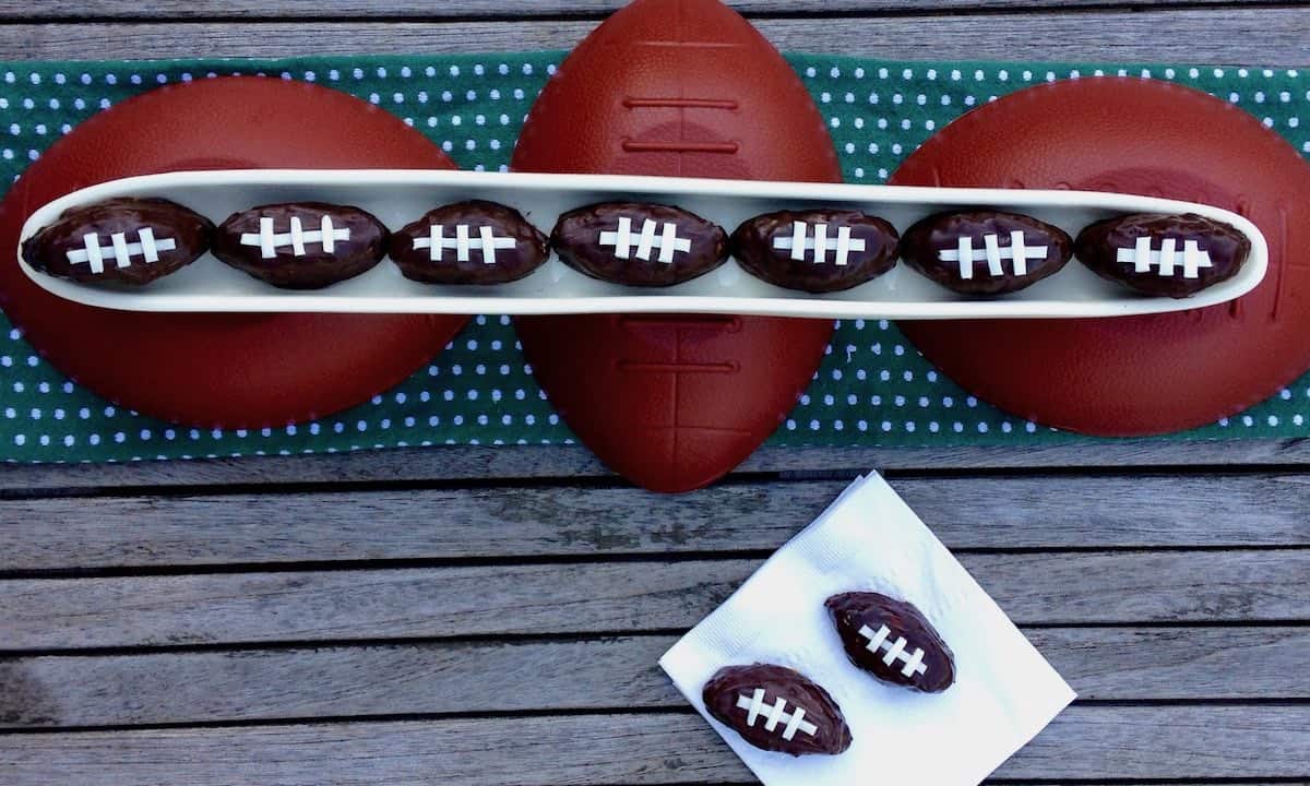 Chocolate covered salted caramel PB pretzel balls decorated to look like footballs.