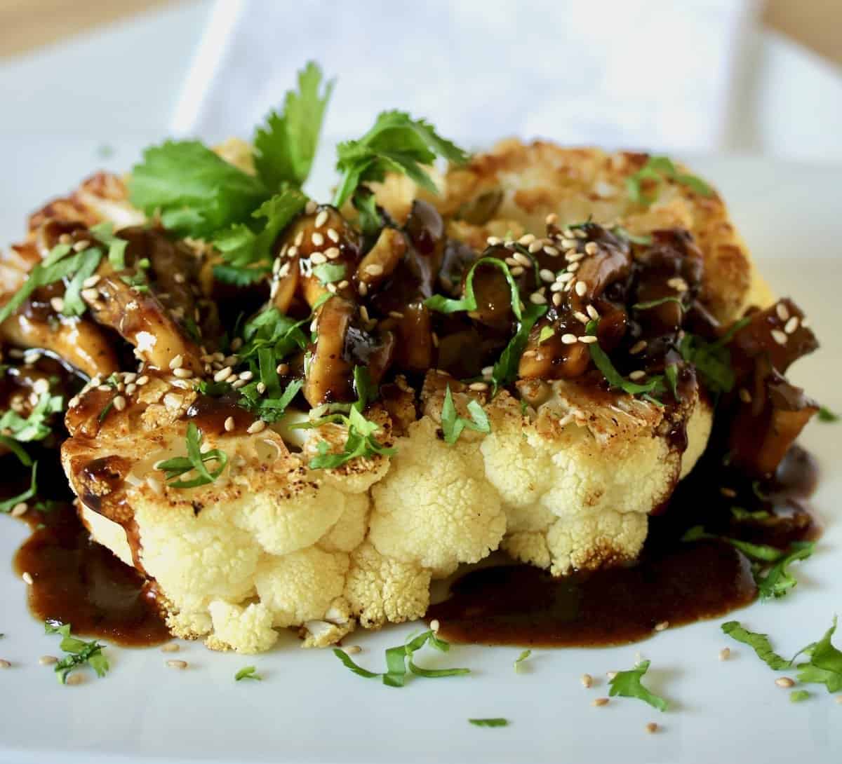 Plated cauliflower steak with Korean BBQ mushroom sauce.