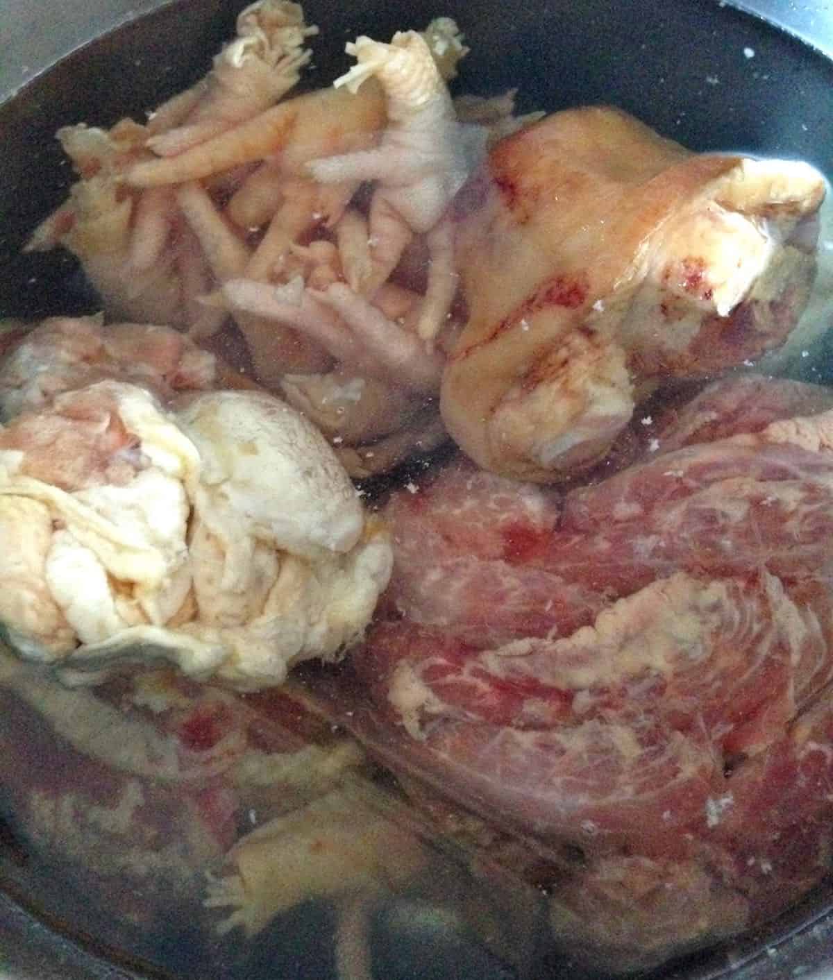 Making chicken broth with a variety of animal parts.