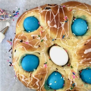 Braided Easter bread with sprinkles and colored eggs.