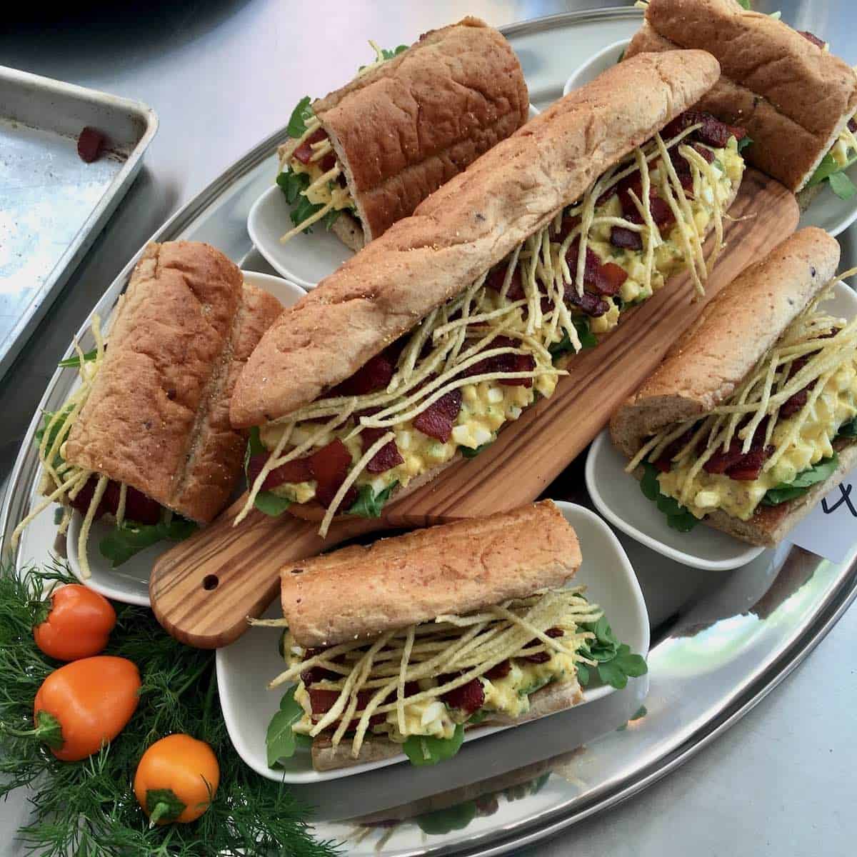 Toasted Egg Salad Roll with Candied Orange Habanero Bacon and Crispy Smoked Potato Strings.