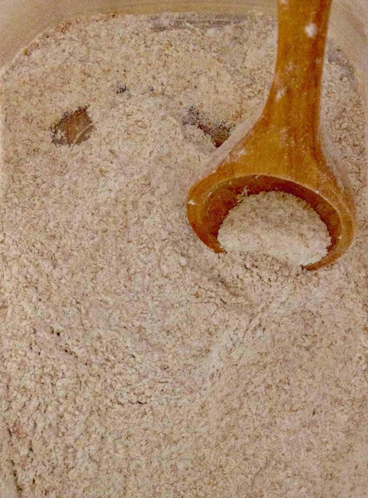 white whole wheat flour with wooden spoon for Whole Grain Easter Muffins