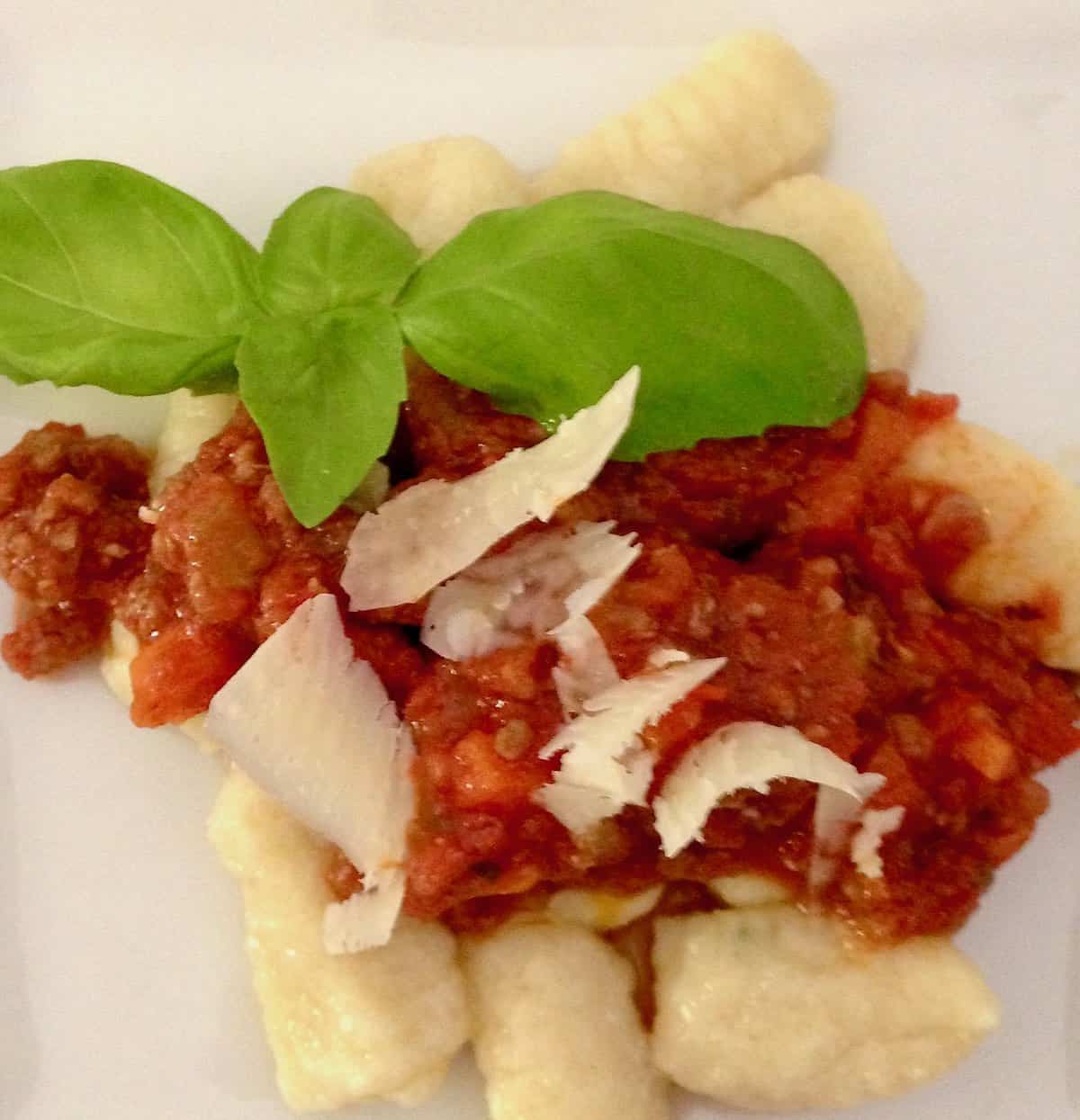 Ricotta Chive Gnocchi Recipeg with red sauce and basil.