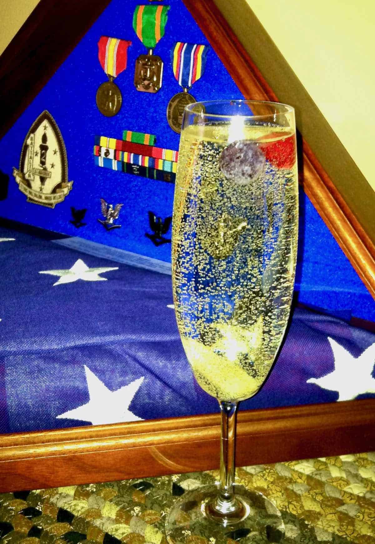 his flag, medals and a sparkling cocktail