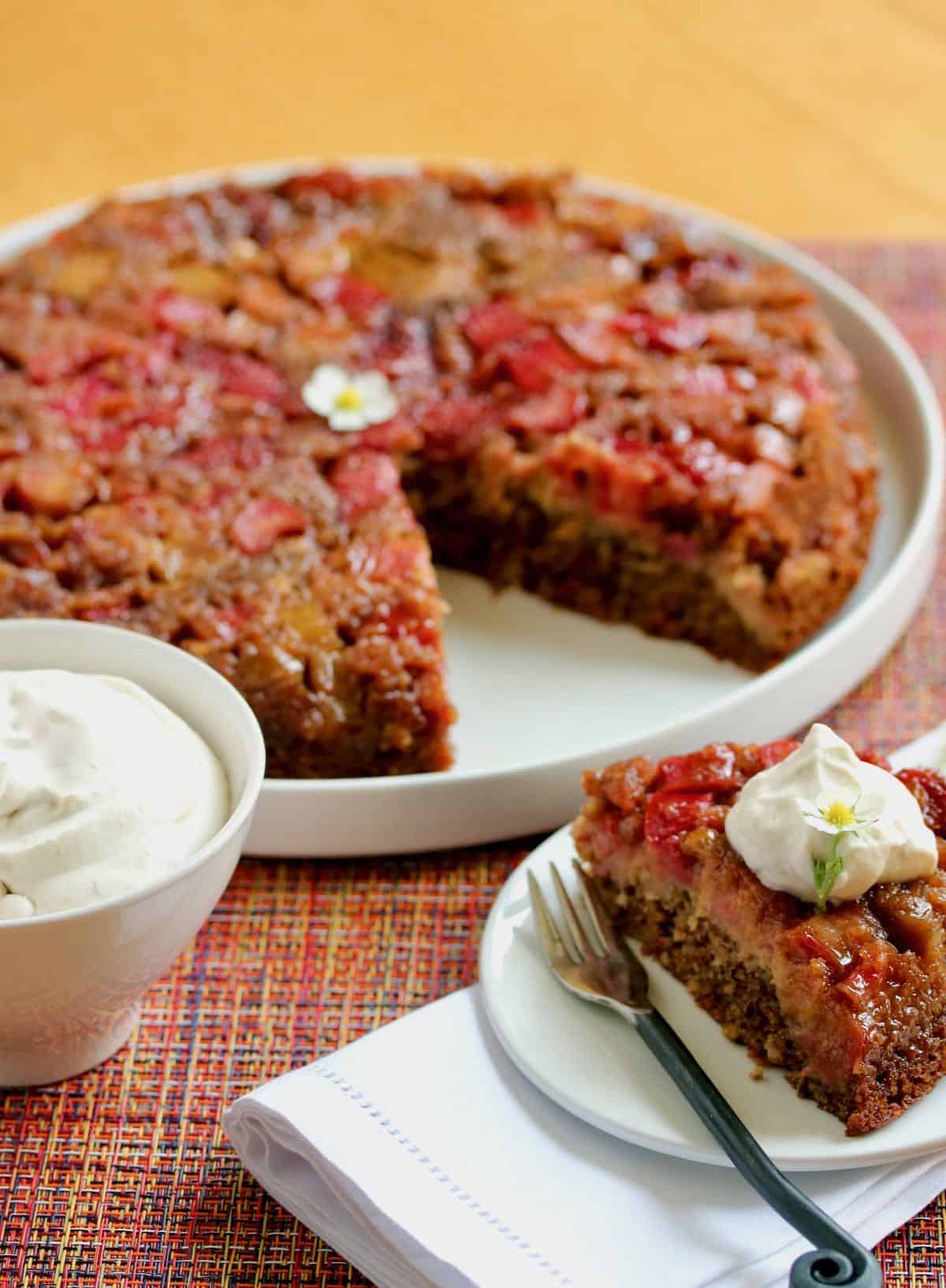 Strawberry rhubarb skillet cake sliced with bowl whipped cream. one of my winning recipes.