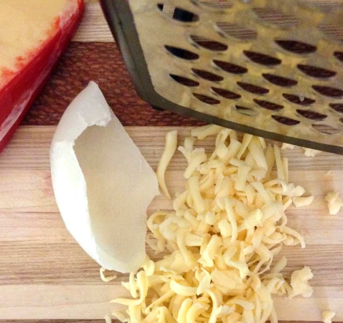 Shredding cheese on box grater.