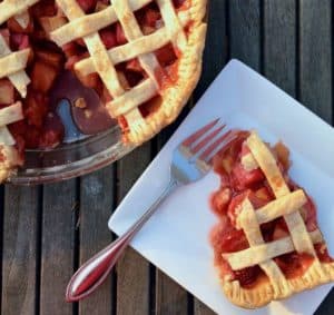Sliced strawberry rhubarb pie on a plate with fork.