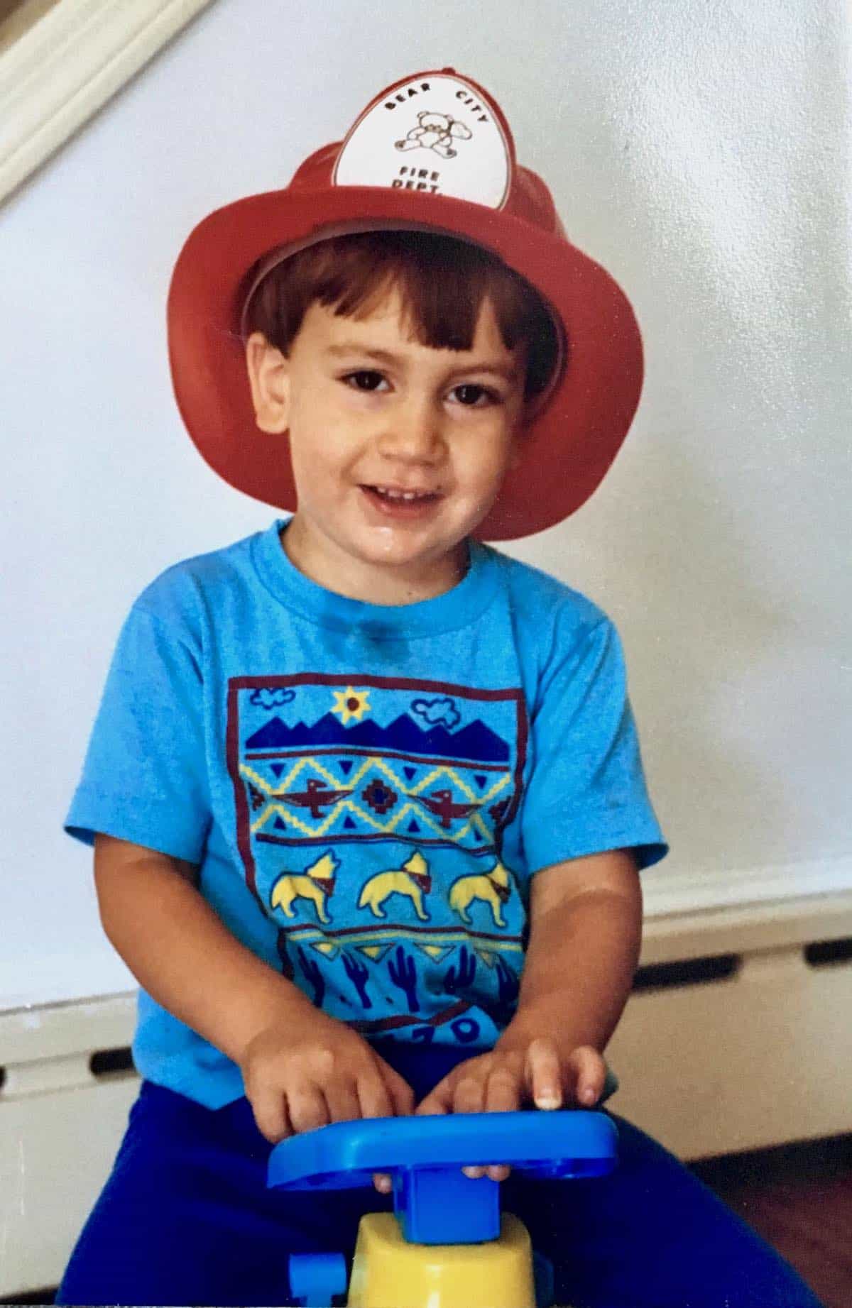 Toddler William wearing a fireman's hat.
