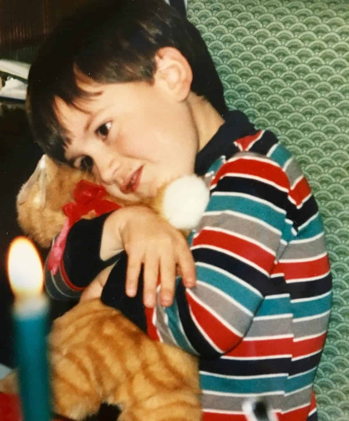Young William hugging his kitty.