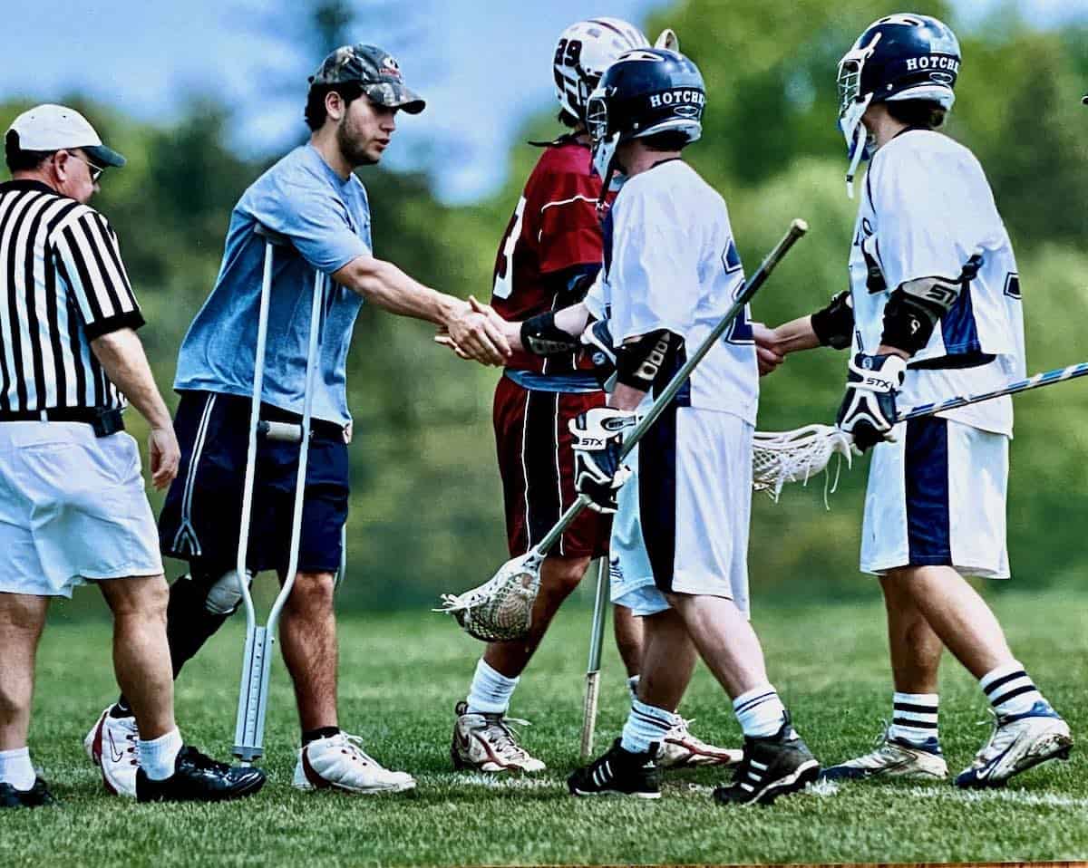 my son post knee injury on lacrosse filed shaking hands with opposing team
