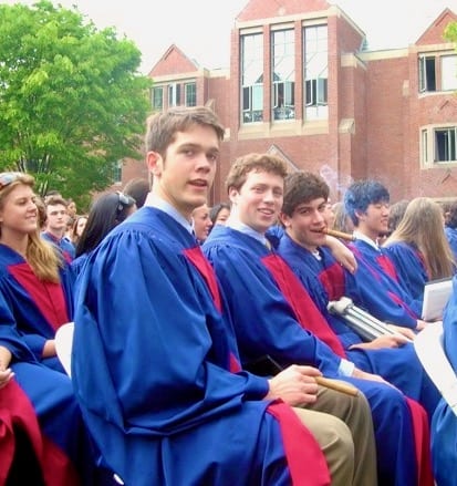 Friends at high school graduation smoking cigars.