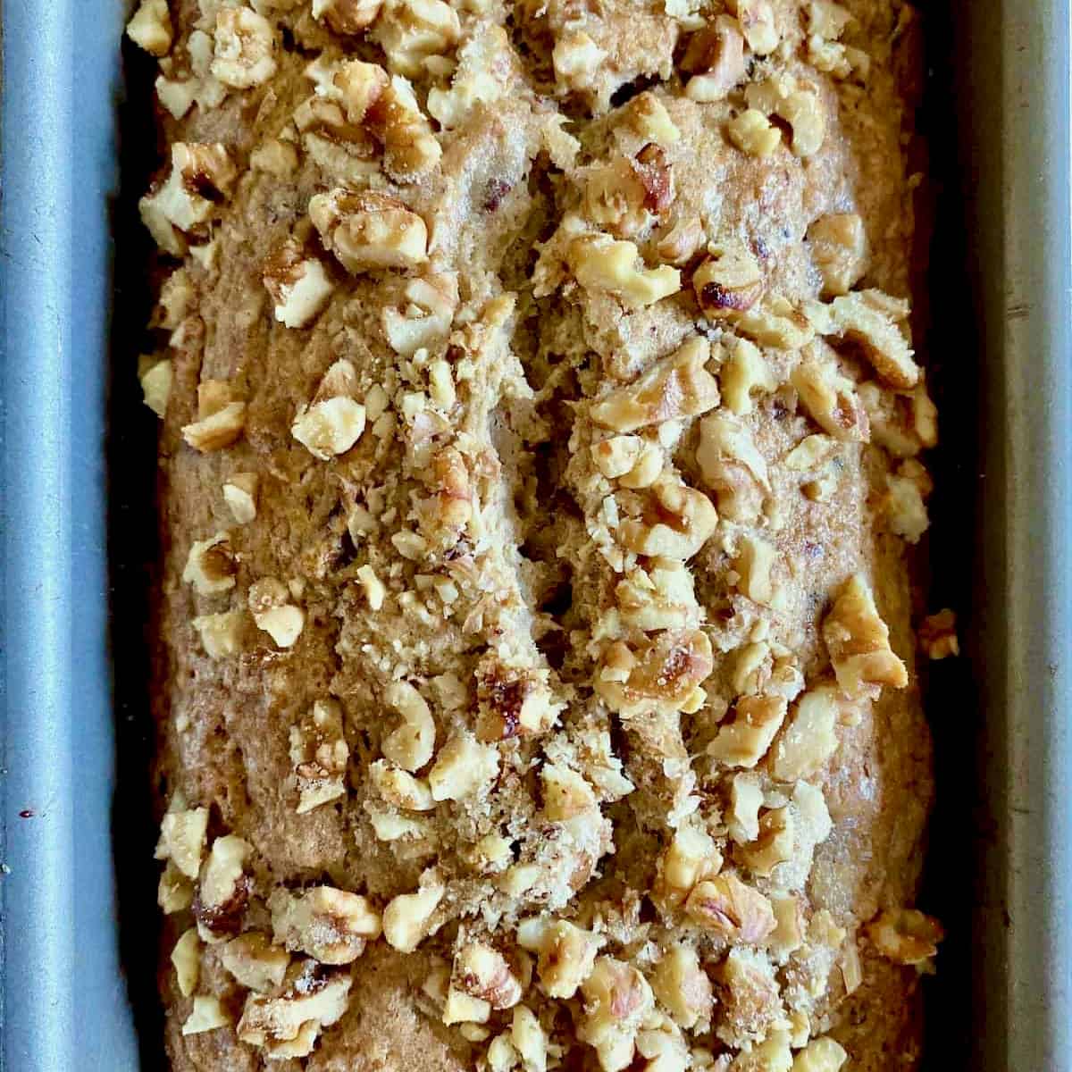 Loaf of banana bread topped with nuts.