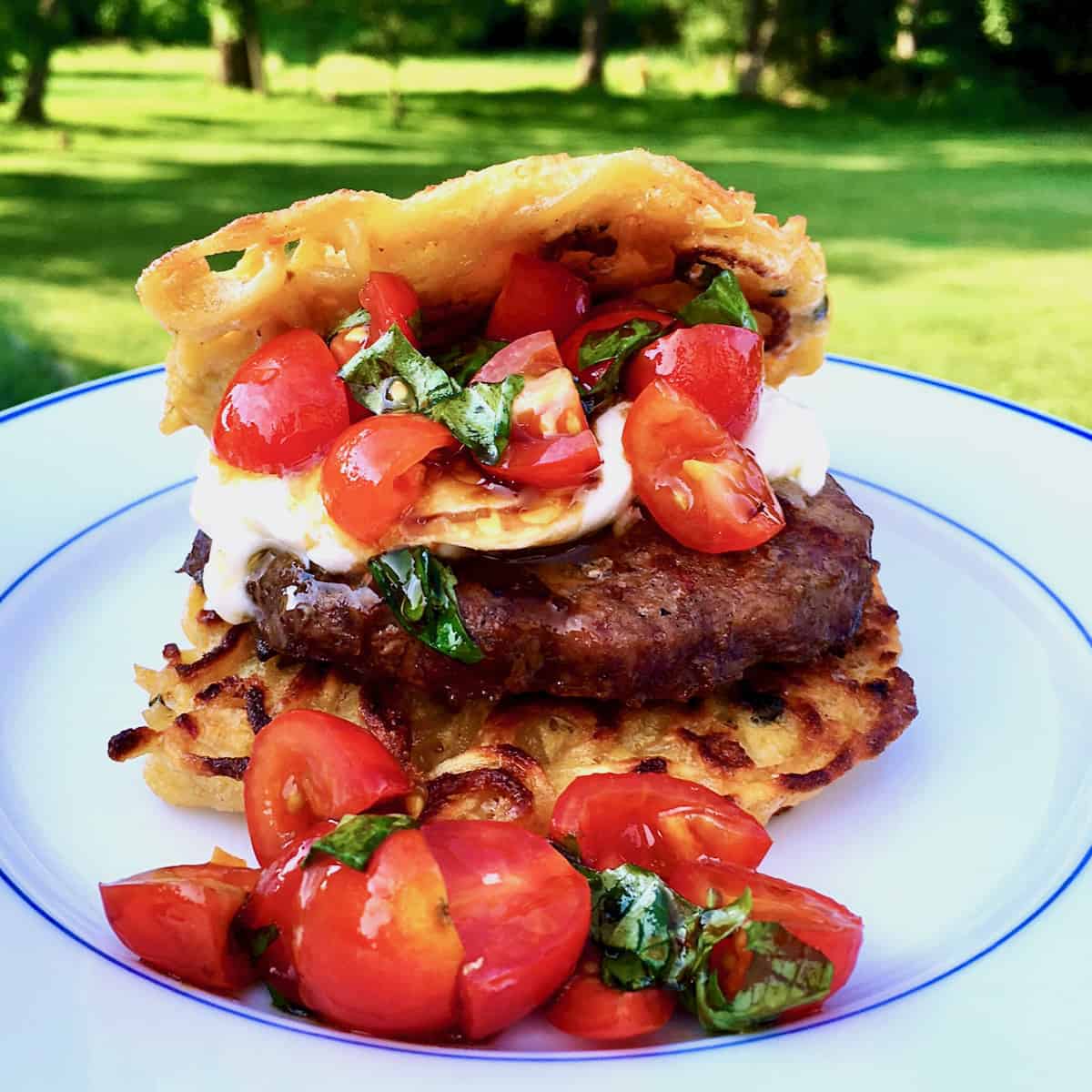 Yakisoba noodle bun burger with tomatoes and cheese.