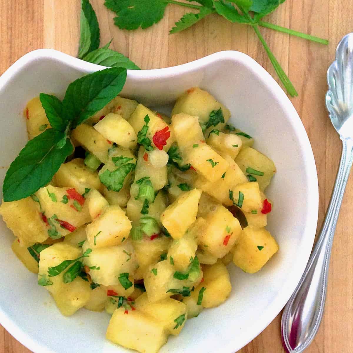 Jezebel salsa in bowl with a spoon and cilantro.