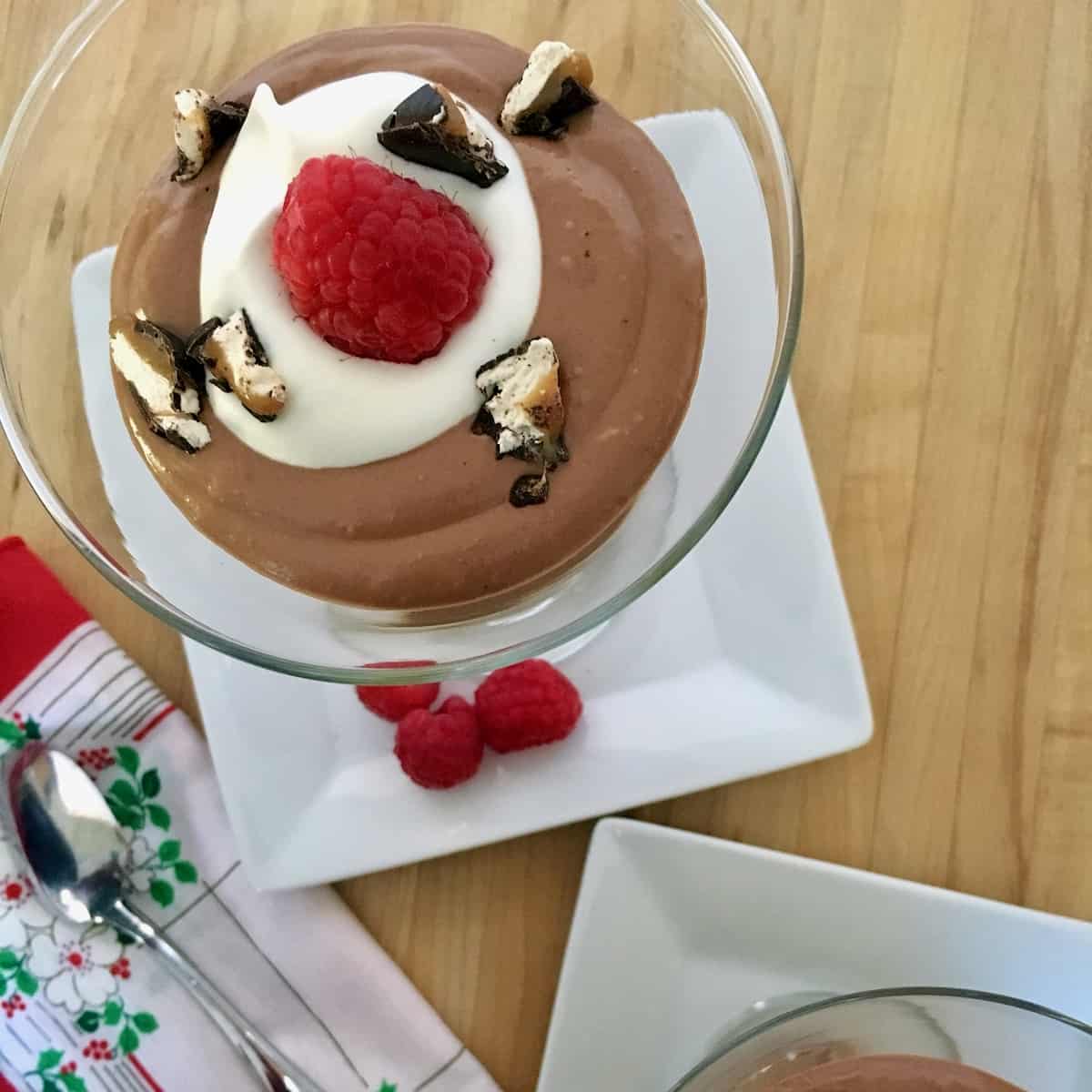 Milky way midnight mousse is the easiest dessert ever chocolate mousse in martini glass topped with raspberries and chopped candy.