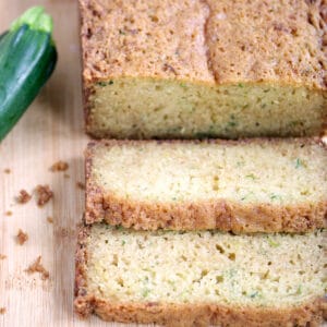 Sliced zucchini bread with fresh zucchini.