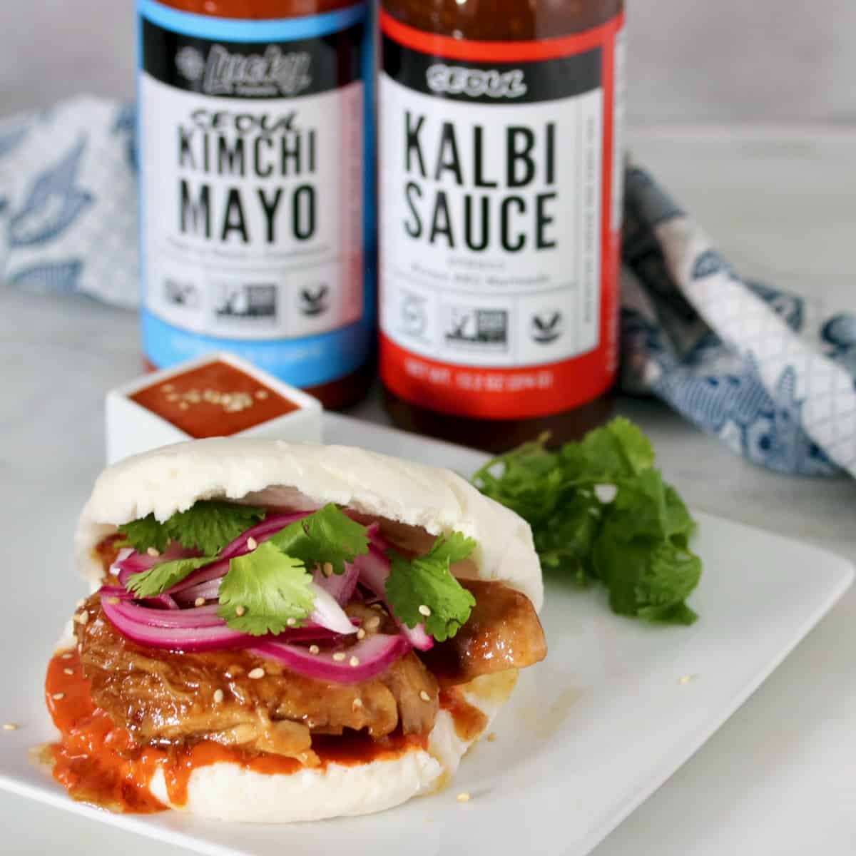 kalbi chicken steam bun with product bottles