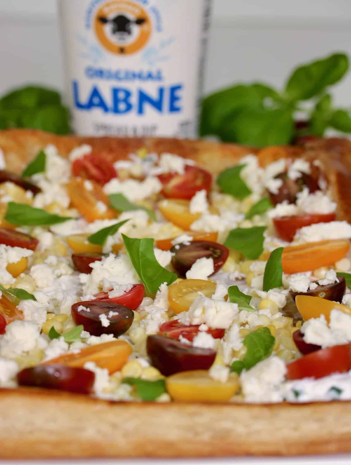 Labne corn and tomato tart with labne container.