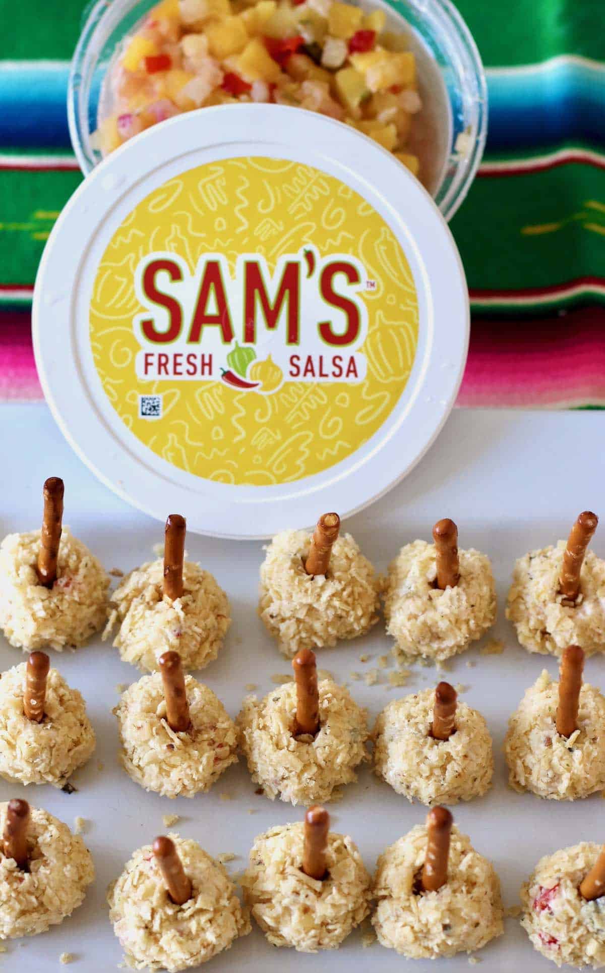 Salsa cheese ball pops with container of Sam's salsa.