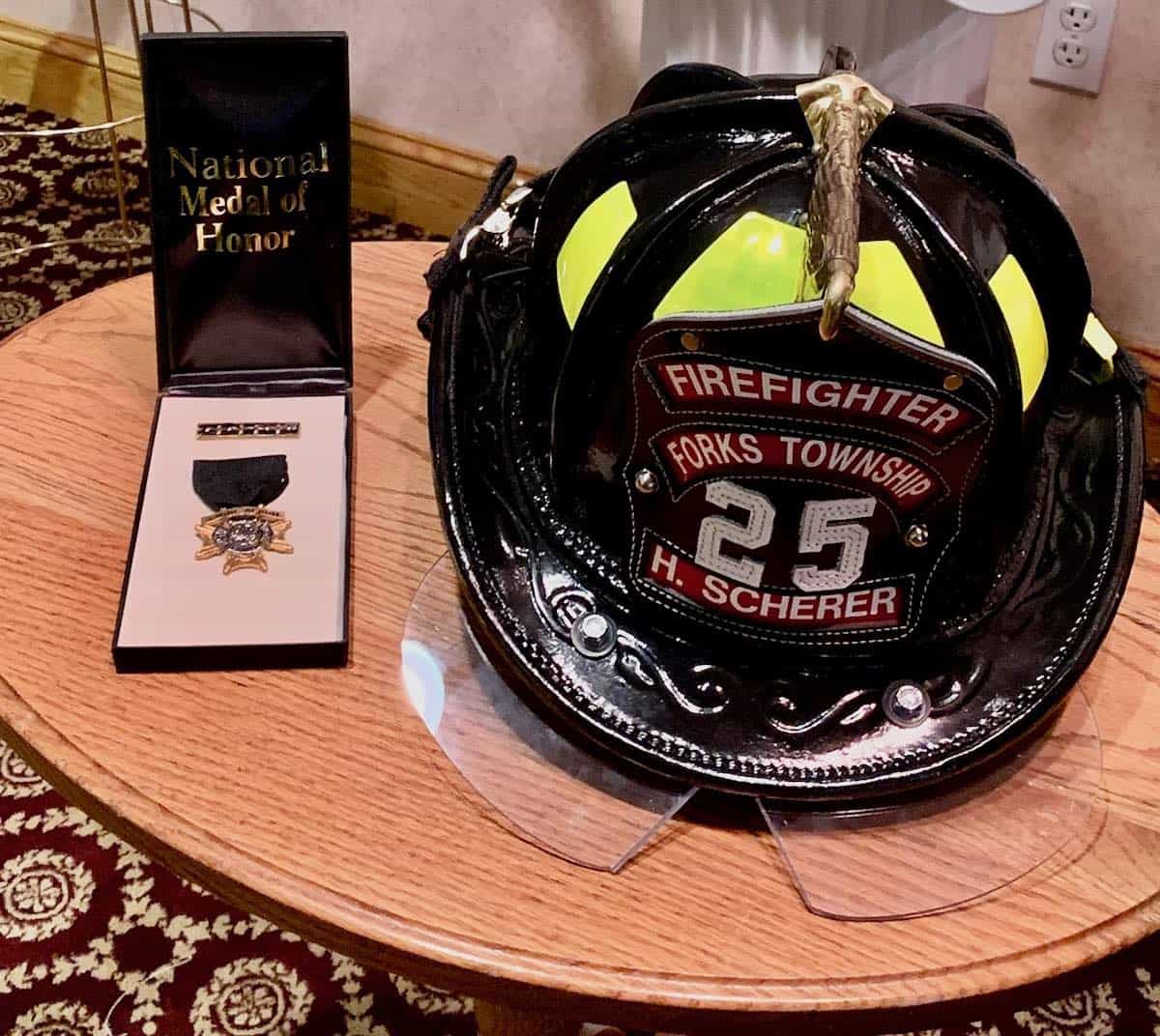 Firefighter helmet and medal of honor; a teen celebrates a hero.