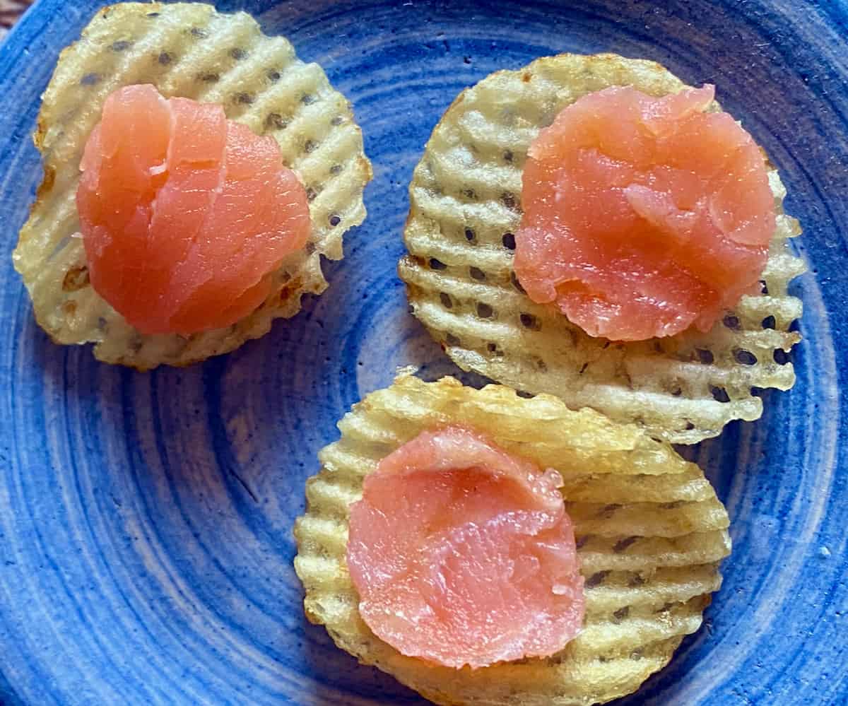 Cut slices of smoked salmon on waffle chips.