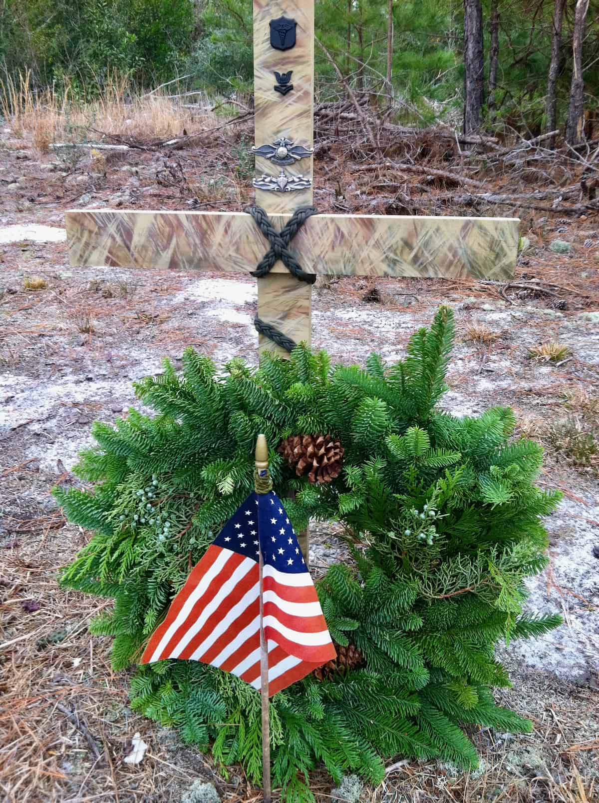 Roadside tribute of military cross, wreath and American flag.
