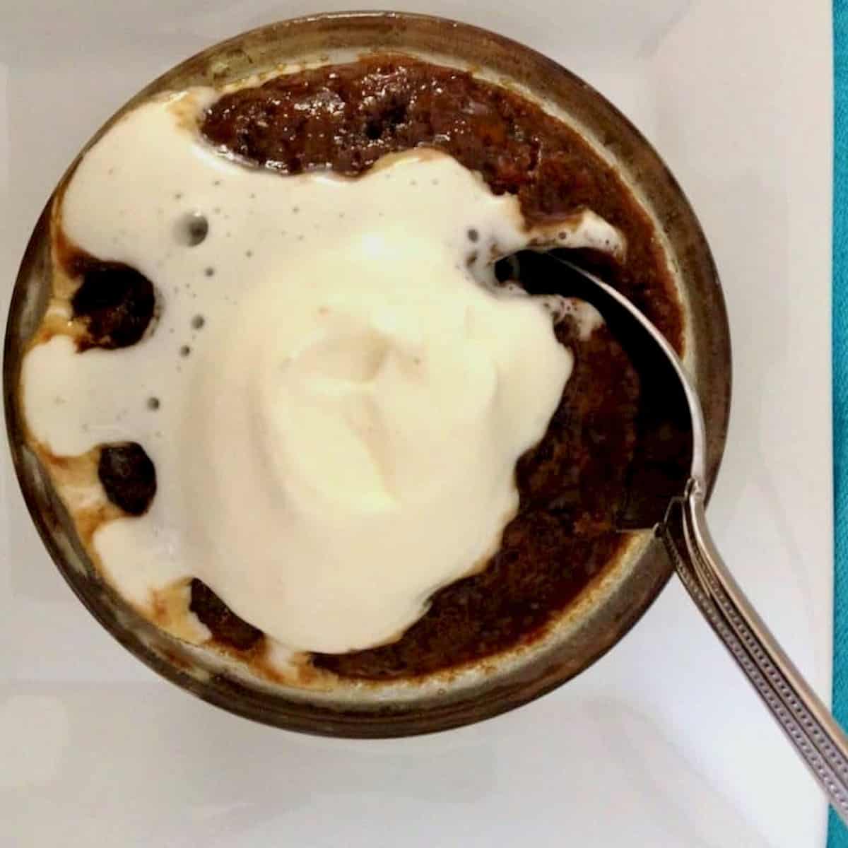 Sticky toffee pudding with cream on top.