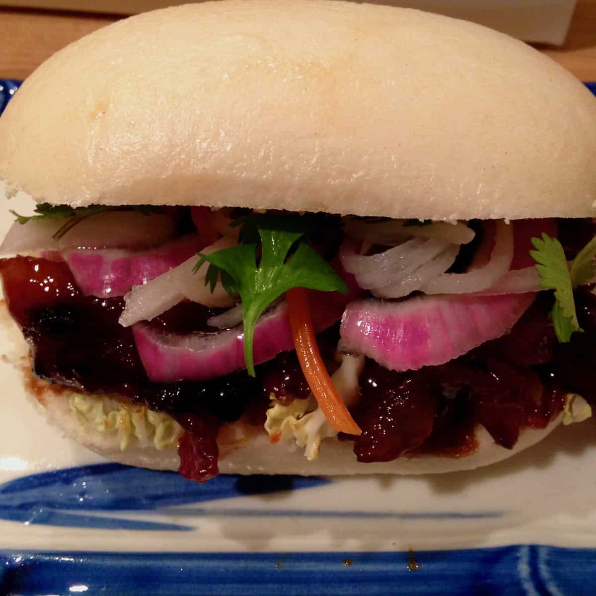 Braised Bacon Steam Bun with Smoked Quick Pickle.